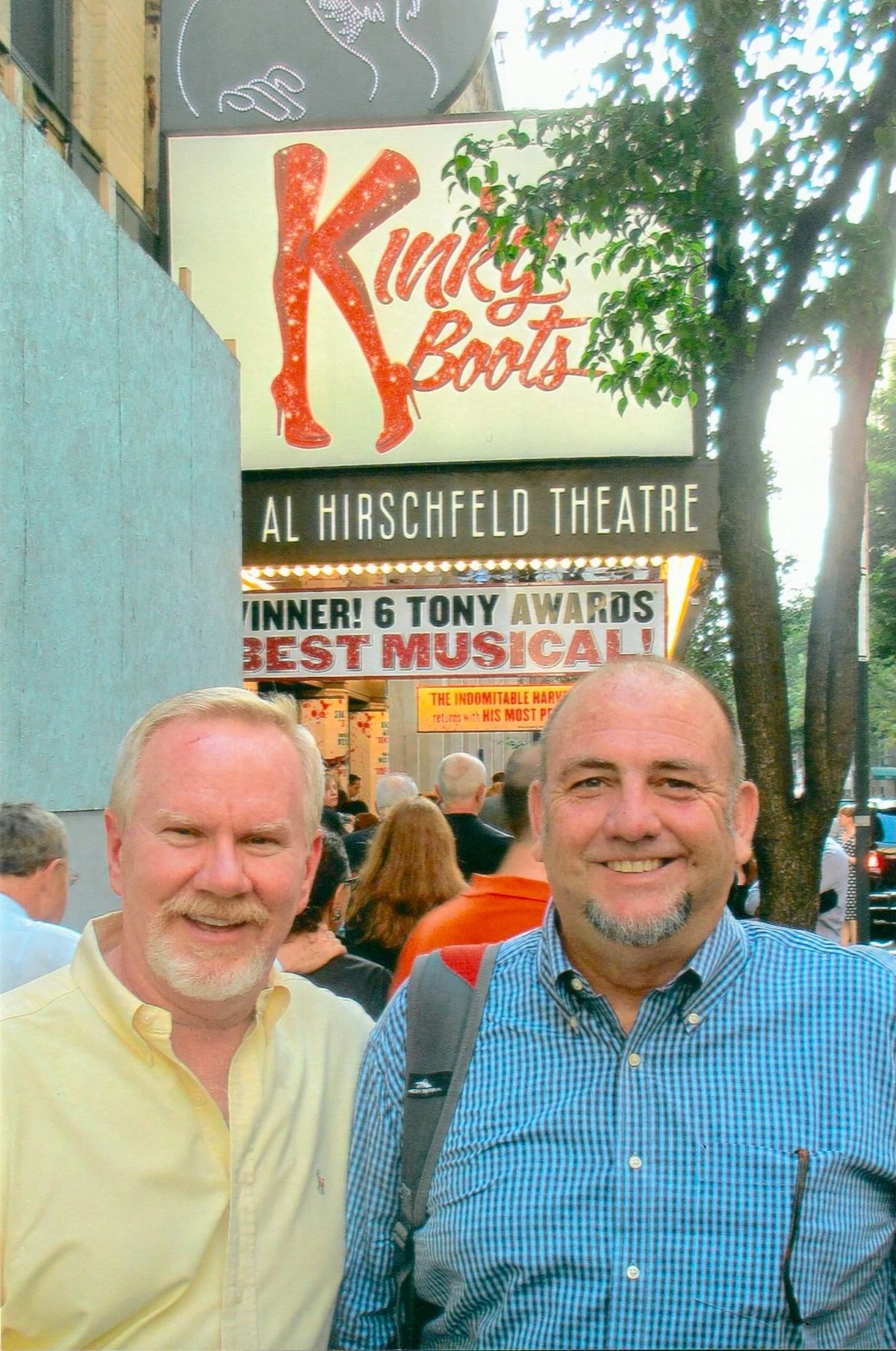 Tom Dyer and John Tanner in front of the Kinky Boots Broadway sign, 2013, New York City, NY. Tom shares, “Many talented Watermark contributors eventually relocated to New York City. I began making regular trips and developed a defining love of the city and Broadway theater. My friend, John Tanner, and I saw Kinky Boots in 2013.” Photo courtesy of Tom Dyer.
