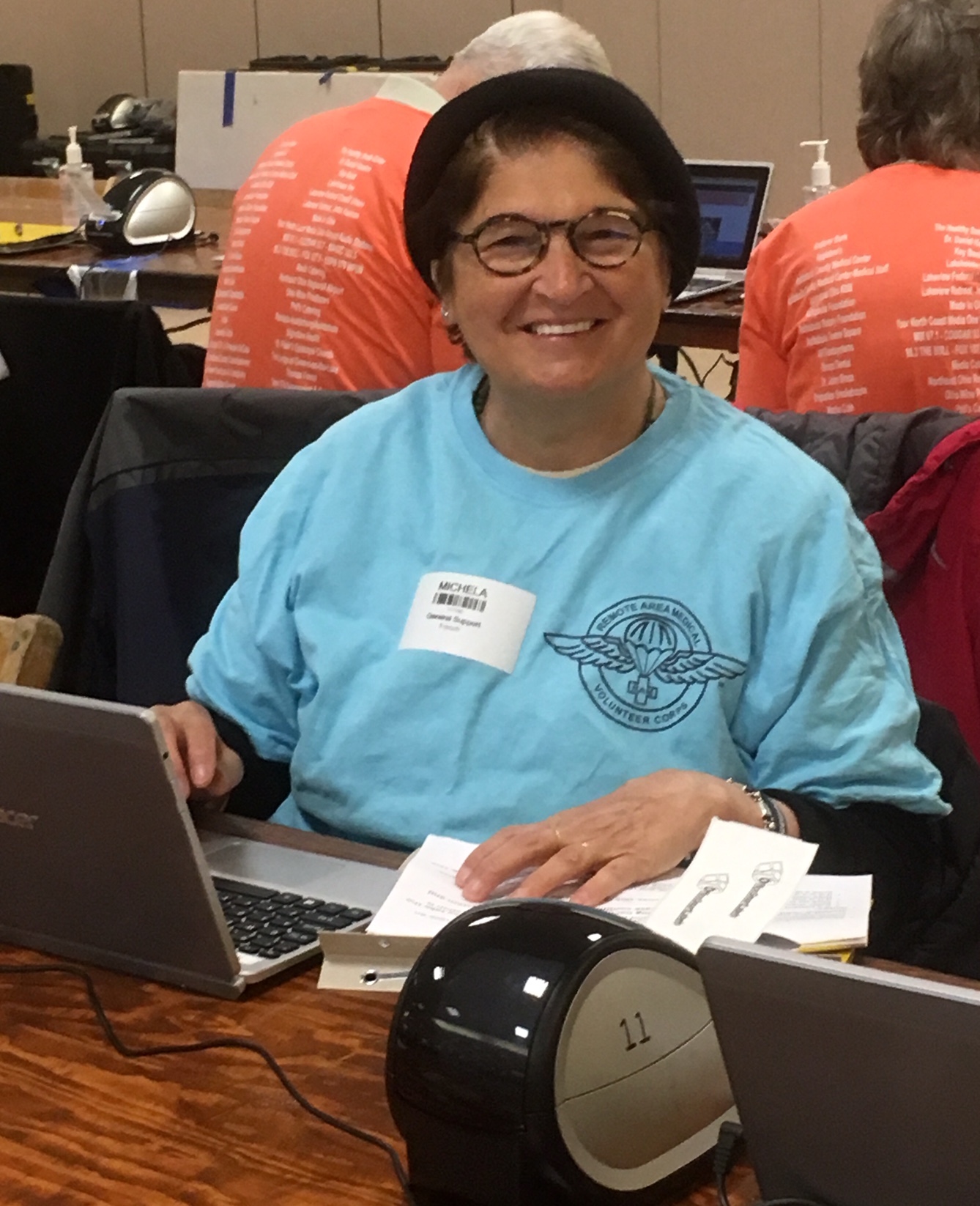 Michela as a social worker, on the job at Remote Area Medical, Ashtabula, OH, April 2018. She shares, “I am at my desk ready to meet patients at 5:30 AM. My day starts at 6:00AM and ends when the last person has been seen. We go to the poorest parts of the United States.” Photo courtesy of Michela Griffo.