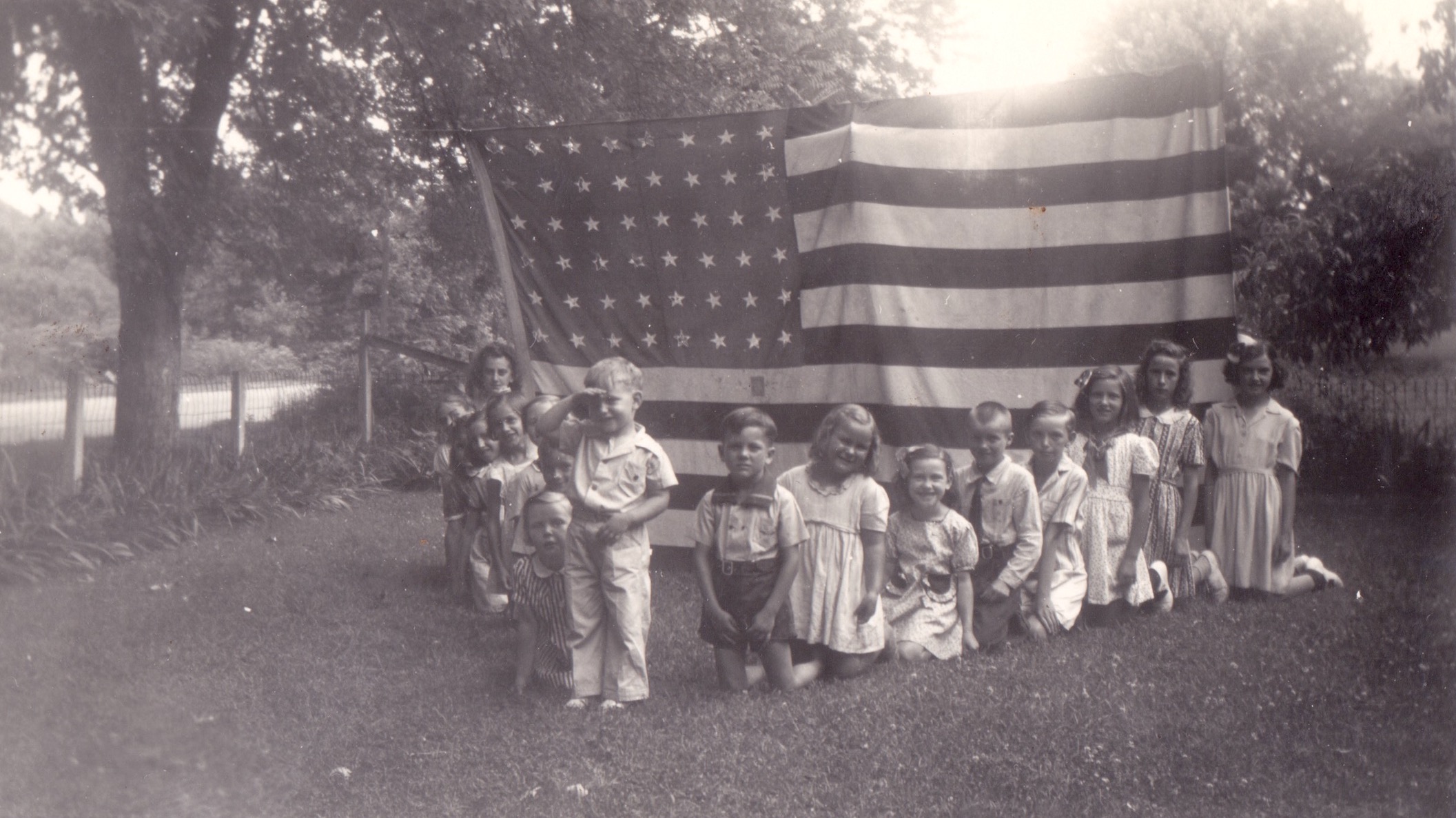 K.C. Potter leading the pledge of allegiance during WWII in front of a group of unknown children, Fallsburg, KY. 