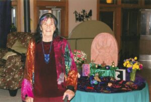 Diana as co-creator of the Goddess Festival, standing next to her altar which includes her artwork, Northwest Arkansas.