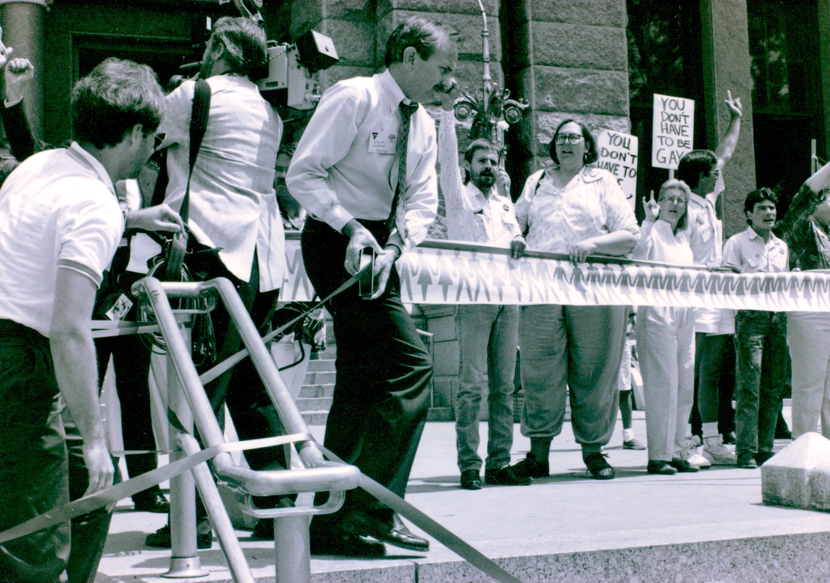 William wrapping the Texas Capitol in symbolic red tape during an AIDS demonstration in front of religious protestors, Austin, TX, circa 1987. Photo courtesy of William Waybourn. 
