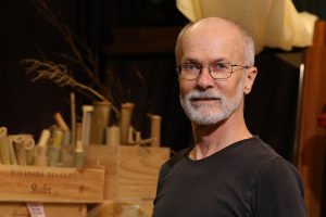 Charles in his art studio of over a decade, 2017. In the background are pieces of bamboo, grown in his back yard, which he uses in mixed-media sculptures.