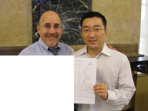 Evan and Cheng hold up their marriage license.