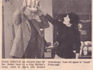 Jan Edwards (stage director) helps the Rev. Herbert Neale try on King Melchior’s crown.