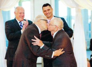 Jim Darby and Patrick Bova kiss at their wedding while Illinois Gov. Pat Quinn (left) and Lambda Legal’s Jim Bennett (right) applaud, June 2, 2014 at the Museum of Contemporary Art, Chicago, IL. Photo Credit: Cindy Fandl.