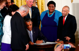 Kylar Broadus watches President Barack Obama sign the executive order barring anti-LGBT job bias, July 21, 2014.