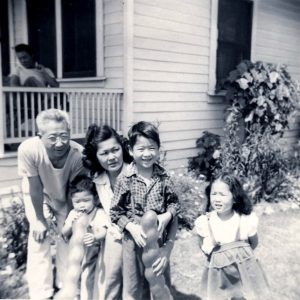 Mia Yamamoto with family at childhood home, c. 1949. L-R: Father Elmer Shosaku Yamamoto; younger brother, David Timothy; mother, Frances Wakayo Yamamoto; Mia; and sister, Monica.
