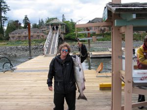 Dee poses with salmon, caught off the coast of British Columbia, Canada, 2004. Photo courtesy of Nanette Gartrell and Dee Mosbacher.