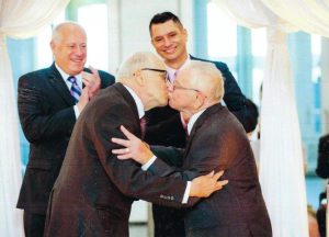 Jim Darby and Patrick Bova kiss at their wedding while Illinois Gov. Pat Quinn (left) and Lambda Legal’s Jim Bennett (right) applaud, June 2, 2014 at the Museum of Contemporary Art, Chicago, IL. Photo Credit: Cindy Fandl. Photo courtesy of Jim Darby.