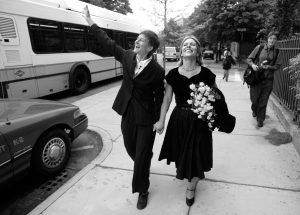 Robyn Ochs and Peg Preble on their wedding day. After obtaining a waiver of the 3-day waiting period from the Court House, they walked to the Town Clerk’s office and became the first same-sex couple married in Brookline, MA on May 17, 2004. (Photo Credit: Laurie Swope)
