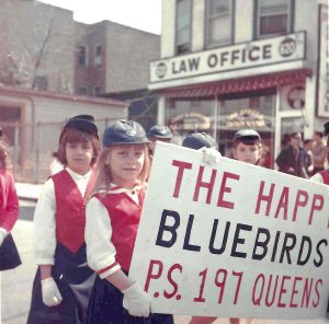Robyn Ochs, age 7, holds the banner for Bluebird troupe, “The Happy Bluebirds of P.S. 197 Queens.” (Courtesy of Robyn Ochs)