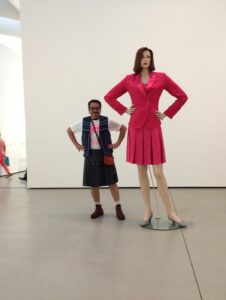 Jolino mimicking the statue of a woman in a pink suit, the Broad, Los Angeles, CA, 2019.