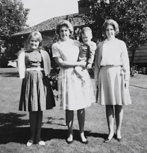 L-R: Robin Freeman (sister), Georgie Freeman (mother) holding Chris Freeman (at age ~1), and Carol Freeman (sister) in front of their house on Woodridge Hill, Bellevue, WA, October 1963. Photo courtesy of Chris Freeman.