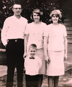 L-R: Donald Freeman (father), Carol Freeman (sister), Robin Freeman (sister), and Chris Freeman (at bottom) as a child in their backyard on Woodridge Hill, Bellevue, WA, Easter 1965. Photo courtesy of Chris Freeman.