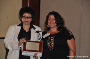 L-R: Awardee Beverly Greene – holding her award from the American Psychological Association (APA)’s Division of the Psychology of Women’s Section on Lesbian Psychologies – and presenter Anneliese Singh at the Laura Brown Award ceremony in 2009. Photo courtesy of Beverly Greene.