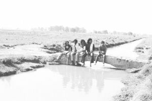 Arvind (at left) with friends sitting on a bridge over a canal near campus, 1977.