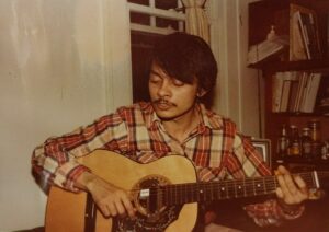 Arvind as a graduate student playing guitar, Rochester, NY, 1981.