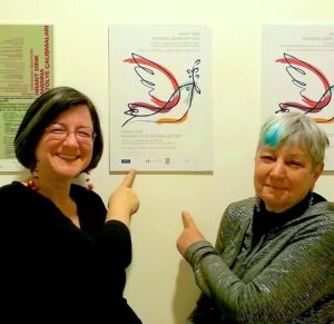 Ayse Gul Altinay (a colleague and dear friend) and Arlene Avakian pointing to the poster for the Hrant Dink Memorial Workshop, 2009. Atlinay invited Arlene to the event. Photo courtesy of Arlene Avakian.