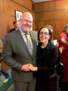 Brett Bigham holding hands with Oregon Governor Kate Brown. Photo courtesy of Brett Bigham.