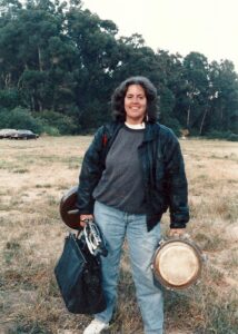 Carolyn at Bort Meadow for the Oakland Drum Festival, 1993. Her motto was “Have drum, will travel.” Photo courtesy of Carolyn Brandy.