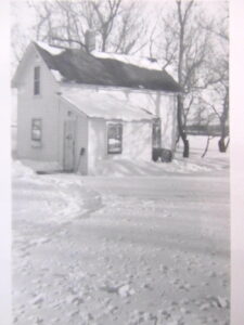 An exterior portrait of the farmhouse Jay grew up in Southwest Minnesota, near the village of Holland, MN (population: 120). Jay shares, “Our small dairy farm was 160 acres. This provides a very good idea of the farm, snow, and the house where I grew up for 18 years.” Photo courtesy of Jay Kyle Petersen.
