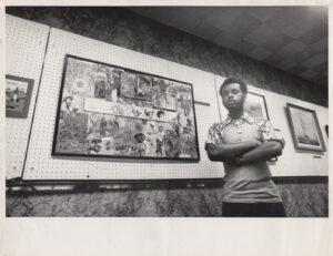 Rupert standing next to his framed collage, which was featured in Chicago SunTimes/Daily News employee art exhibit, 1975.