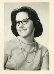 A senior class portrait of Judy smiling with glasses and pearls, Hollywood High School in Los Angeles, CA, 1960. Photo courtesy of Santa Monica Public Library Image Archives, Judy Abdo Photo Album Collection.