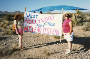 L-R: Helen Albert and Judy Abdo holding a “West Hollywood Citizens for a Nuclear Test Ban” sign with blue and pink lettering, 1990s. Helen Albert was a community activist instrumental in the incorporation of West Hollywood. She served as one of WeHo’s first City Council members. During Albert's tenure, Judy Abdo started West Hollywood's Farmers' Market and then worked as a council deputy in Albert's office. Albert died in 1996 at age 85. Photo courtesy of Santa Monica Public Library Image Archives, Judy Abdo Photo Album Collection.