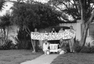 Supporters of Judy Abdo from the Seventeenth Street Tenants Association holding a “Peace on Earth, Good Will Toward Men” sign with a “Judy” sign underneath, 1991. Photo courtesy of Santa Monica Public Library Image Archives, Judy Abdo Photo Album Collection.