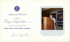 A white card with Kiwanis International letterhead that reads, “An appreciation memento presented to Mayor Judy Abdo in recognition of your address before the Kiwanis Club of Santa Monica, California, March 19, 1991”. A photo of Judy speaking at a podium is attached at right. Photo courtesy of Santa Monica Public Library Image Archives, Judy Abdo Photo Album Collection.