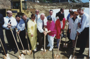 Judy Abdo (middle, in a pink top) and others begin shoveling at the New Hope Housing Services groundbreaking ceremony in Santa Monica, CA, 1997. Photo courtesy of Santa Monica Public Library Image Archives, Judy Abdo Photo Album Collection.