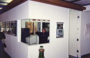 Judy Abdo waving in one of the offices of the Peter Norton Family Foundation, Santa Monica, CA, 1996. Photo courtesy of Santa Monica Public Library Image Archives, Judy Abdo Photo Album Collection.