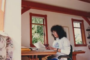 Terri “at work”, typing next to various drafts in the Fir Cottage at Hedgebrook Farm, Whidbey Island, WA, 1993. She drafted 
