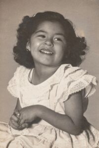 Another portrait of Terri, age 3, in a white dress, 1950. Photo courtesy of Terri de la Peña.
