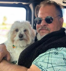 Miguel hugging Baxter as they ride around town in a Jeep, Palm Springs, CA, 2022. Photo courtesy of Miguel Criado.