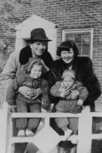 Judith and her brother Richard Masur as children, being held by their parents in front of their childhood home, 1949. Photo courtesy of Judith Masur.