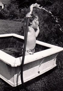 Judy playing with the hose in front of her childhood home, 1948. Photo courtesy of Judith Masur.