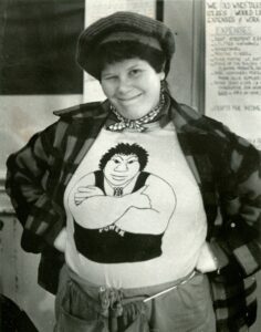 Judith posing and wearing a t-shirt featuring one of her drawings at the Old Wives Tales, 1980. Photo courtesy of Judith Masur.
