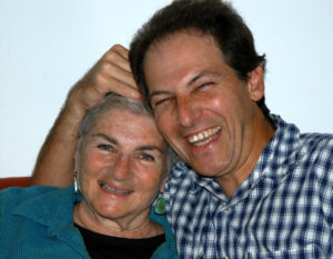 Margaret Randall smiling as her son Gregory Randall holds her head, 2000s. Photo courtesy of Margaret Randall.