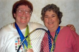 Esther Rothblum and Beth Mintz hugging after receiving medals in racquetball at the Gay Games, Chicago, IL, 2004. Photo courtesy of Esther Rothblum.
