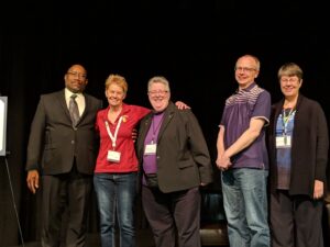 The Out to Innovate Summit Organizing Committee onstage at the University of Southern California, Los Angeles, CA, March 17, 2019. L-to-R: Terry Demby, Amy Ross, Shelley Diamond (at center), TJ Ronningen, and Barbara Belmont.