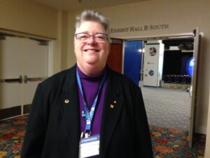 Shelley smiling in front of Exhibit Hall B South at the American Association for the Advancement of Science (AAAS) National Meeting in Washington, DC, February 2016. Photo courtesy of Shelley Diamond.