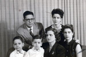 Oliva (at top right) and her family (father and brothers at left, mother and sister at bottom right) posing for a portrait in Cuba. Photo courtesy of Oliva Espín.