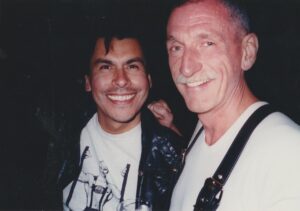 L-R: Robert Gallego and Chuck Forester smiling, 1990. Chuck shares, “Robert inspired Tom Guomo’s “American Boy” poem.” Photo courtesy of Chuck Forester.
