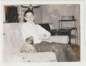 Chuck smiling down at his new puppy Buff, 1959. Photo courtesy of Chuck Forester.