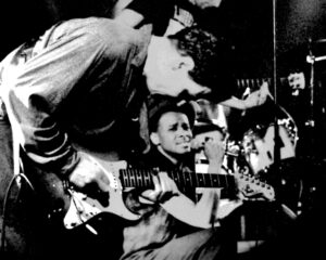 Paul Outlaw (at center, holding microphone) and bandmate Yref (a.k.a. Rainer Frey, at left with guitar) performing as Snow Blind Twilight Ferries in Loft im Metropol, Berlin, Germany, 1992. Photo courtesy of Paul Outlaw.