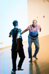 Paul Outlaw (at right) and Joe Seely dancing around each other in DUET, a work-in-progress for LAX (Live Arts Exchange) Festival at MOCA (Museum of Contemporary Art), Los Angeles, CA, 2022. Photo credit: Michael Palma Photography. Photo courtesy of Paul Outlaw by way of Los Angeles Performance Practice.