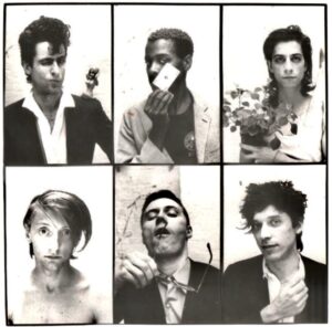 A Die Haut promotional band photo, Berlin, Germany 1985. Clockwise from top left: Christoph Dreher (winking), Paul Outlaw (holding a playing card), Rainer Max Lingk (holding a plant),Remo Park (with a fist out), Thomas Wydler (holding glasses with mouth open), and Jochen Arbeit (staring blankly). Photo courtesy of Paul Outlaw.