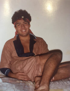 Polaroid of a smiling 20 year-old Dante wearing an elegant brown robe and headband, during his pre-med student years in his dorm at Columbia University, NYC, 1981. Photo credit: former beau Marcello. Photo courtesy of Dante Alencastre. 