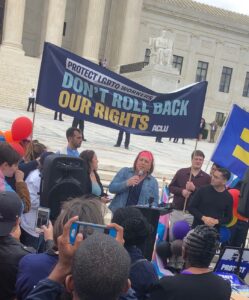 Stephanie speaking on the sidewalk in front of the US Supreme Court Building on October 8, 2019, Washington DC. Inside the building, oral arguments were taking place for Bostock v Clayton County. Photo courtesy of Stephanie Byers.